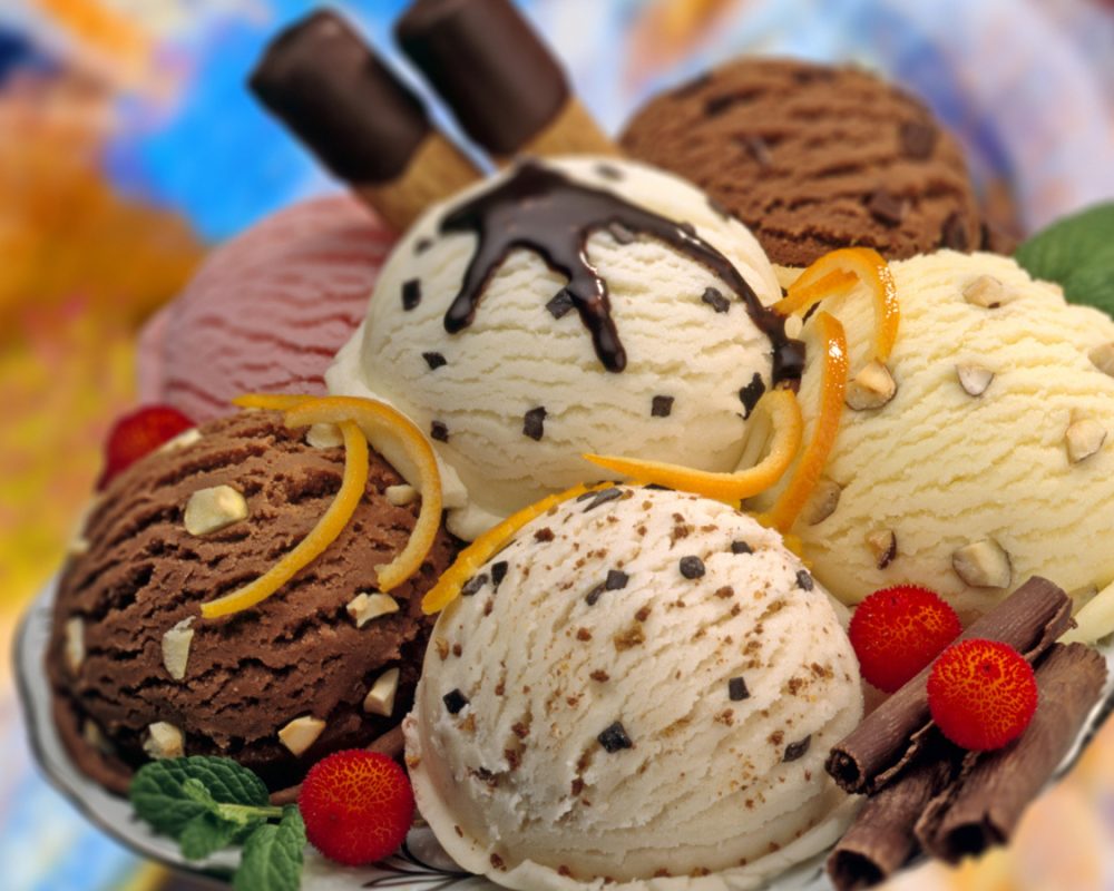 A composition of various flavours ice cream balls decorated with red fruits,chocolate curls and mint